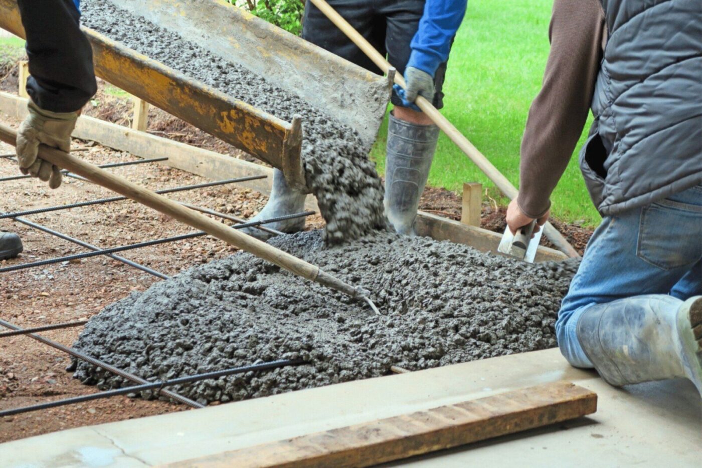 contractors using a specialized machine to pour concrete mixture into the frame