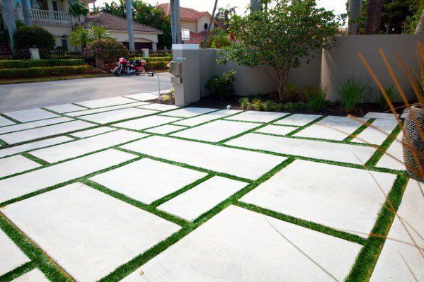 artificial grass installed between paved concrete driveway in Lely FL
